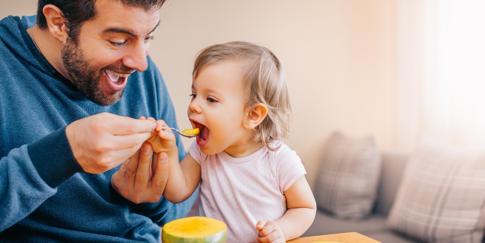 Father feeding his child fruit after tongue tie treatment